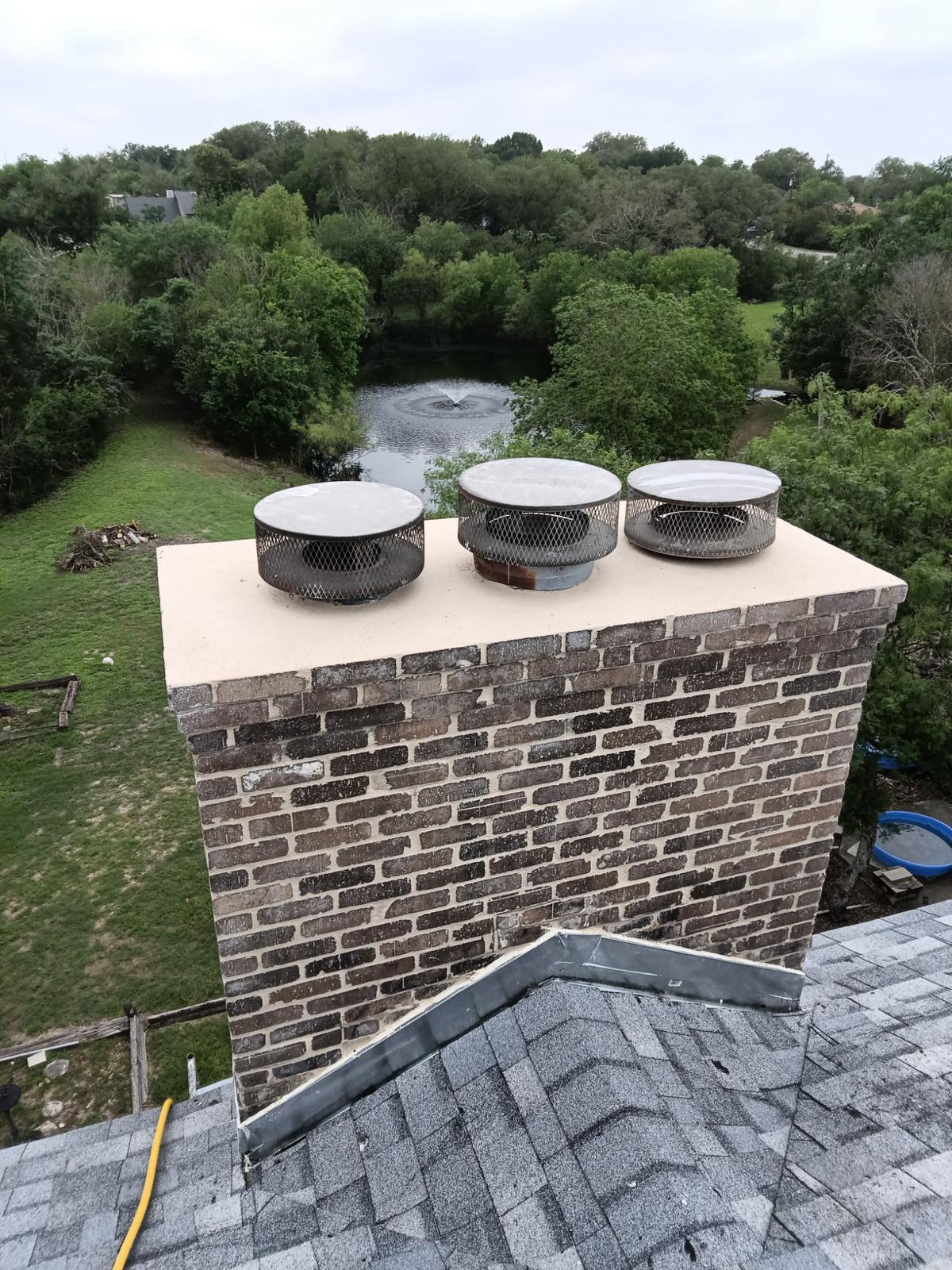 Brick chimney with restored crown and three flue caps