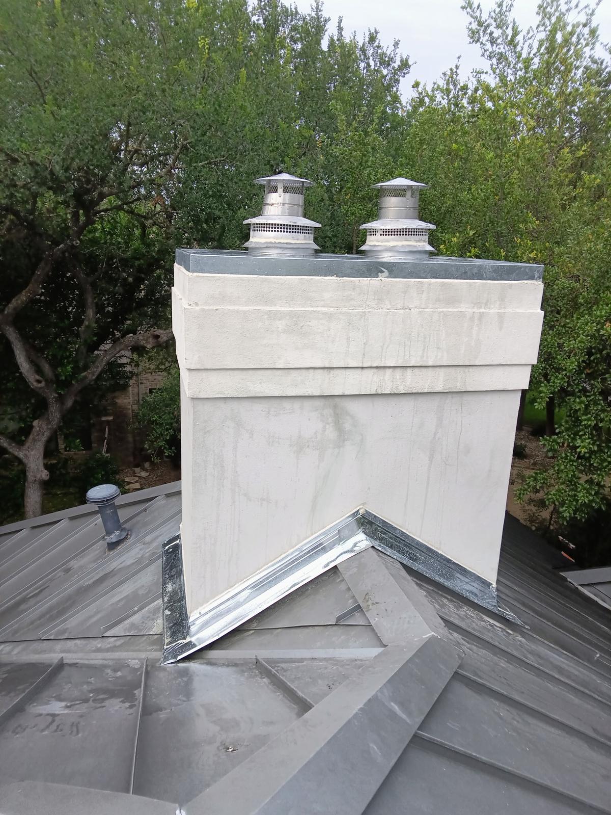 Stucco chimney with two stainless flue caps and new flashing