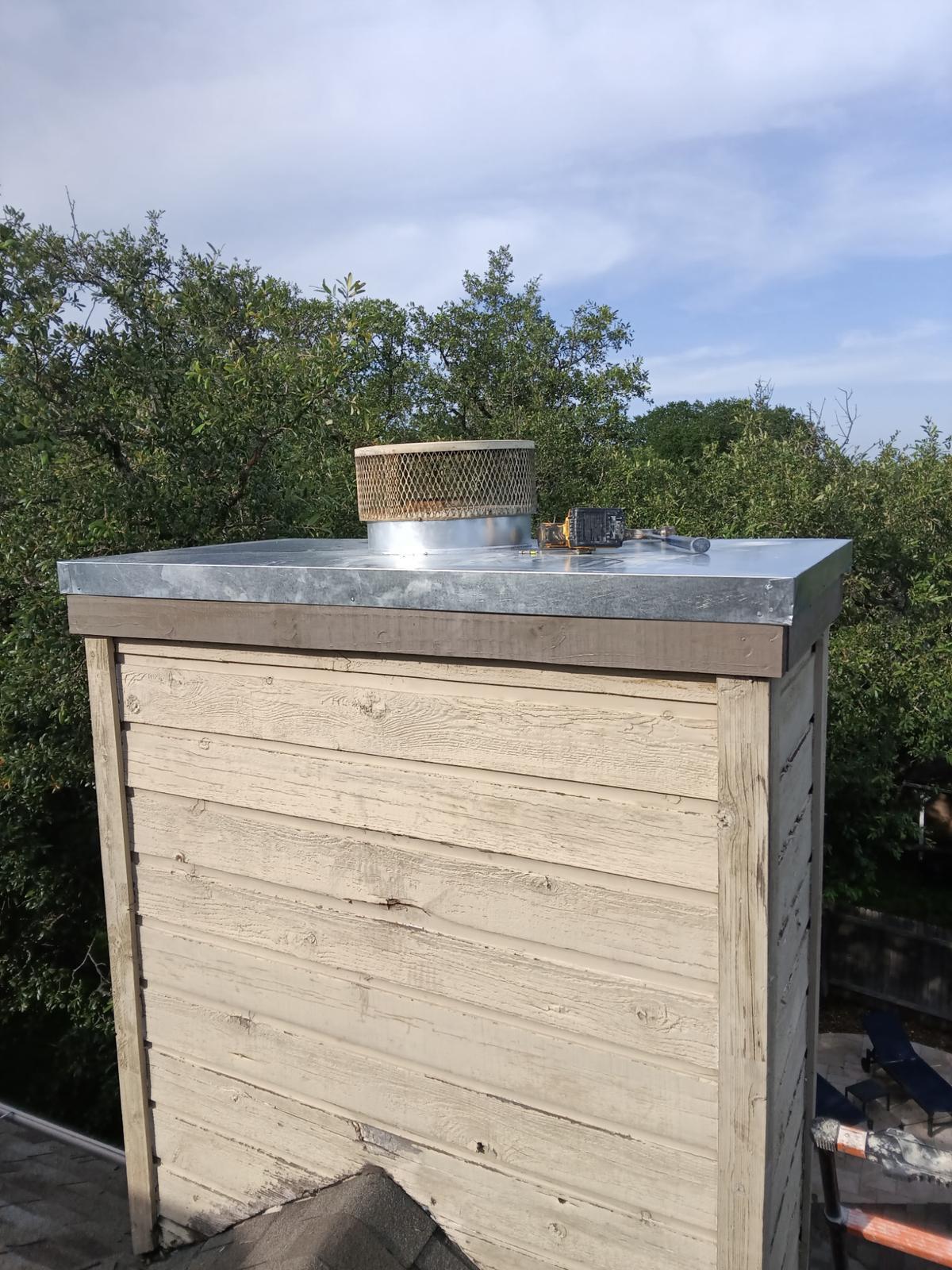 Custom fabricated galvanized chase cover installed on a chimney chase