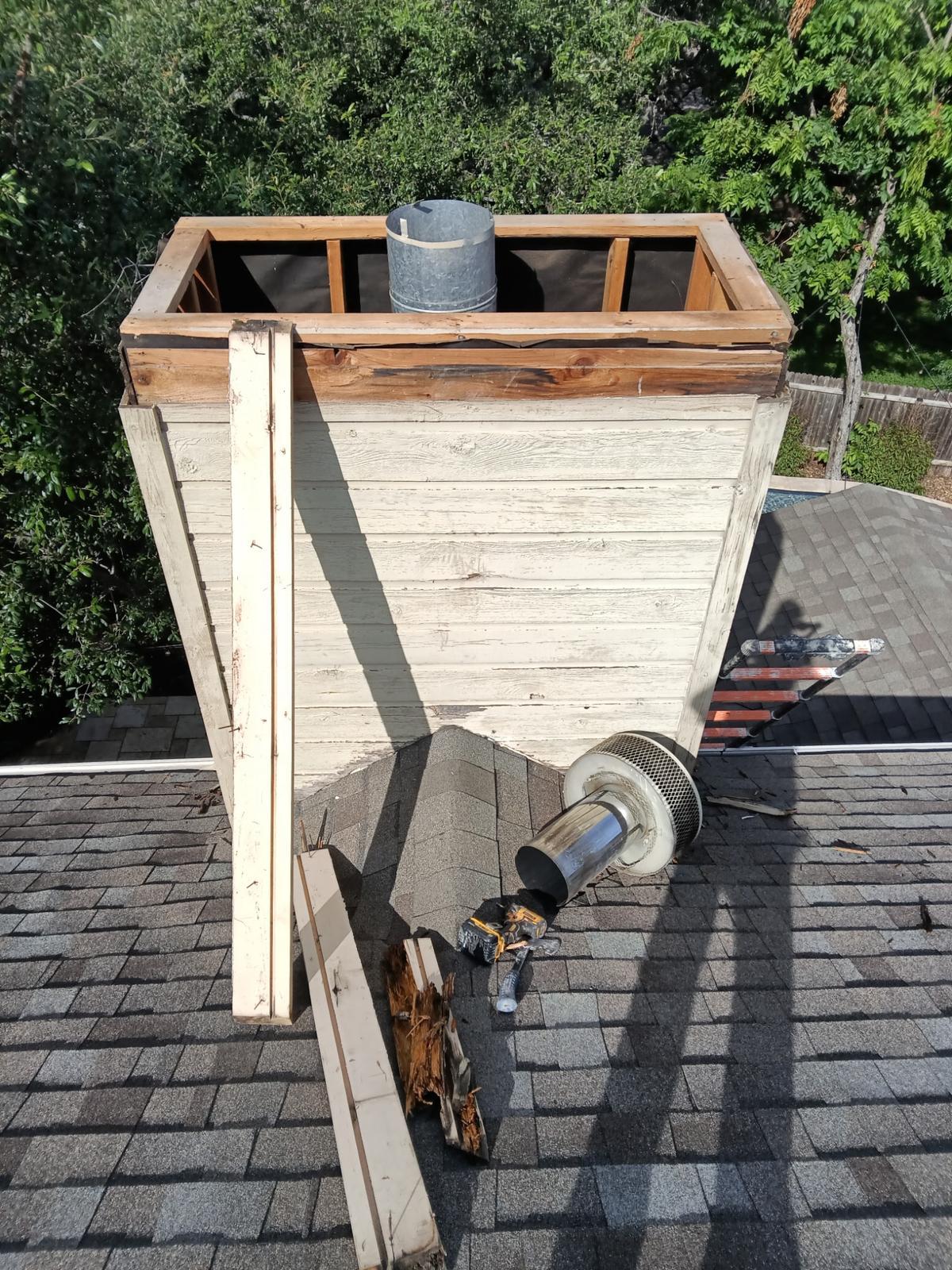 Chimney chase framing rebuild in progress on a rooftop
