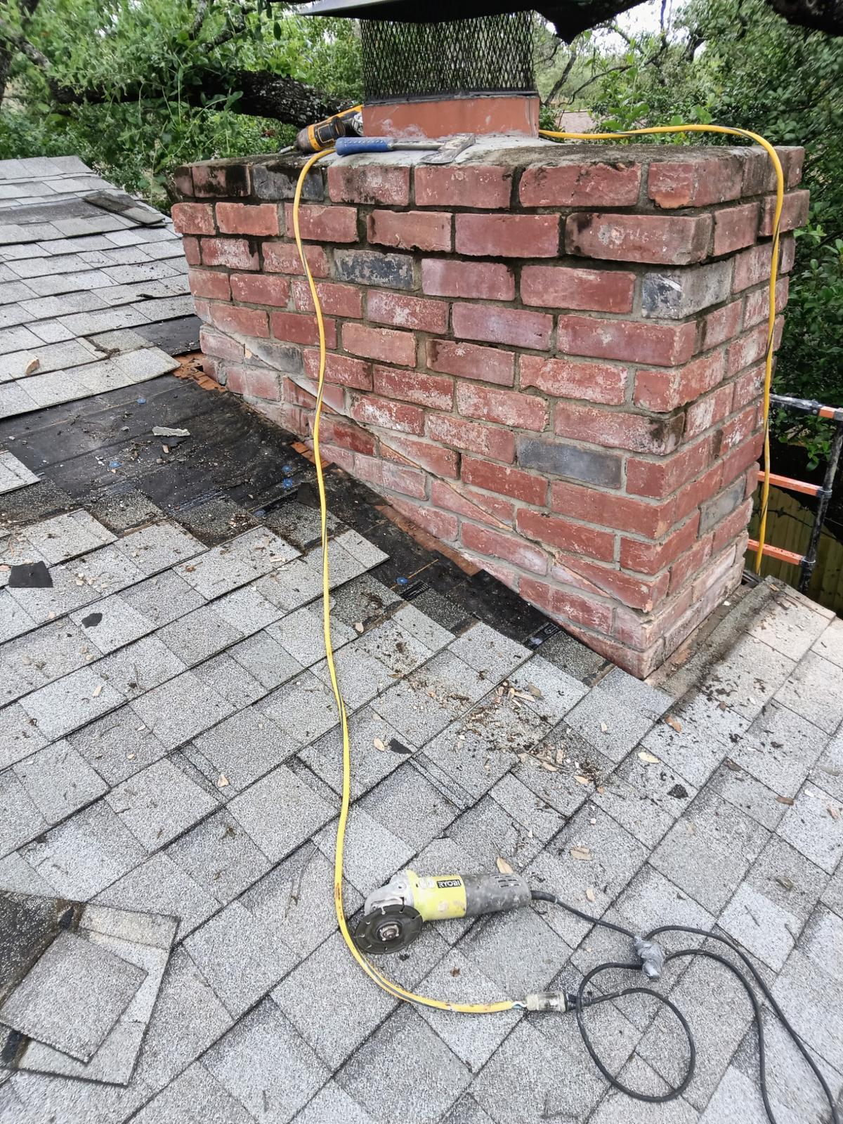 Deteriorated brick chimney prepared for masonry rebuild